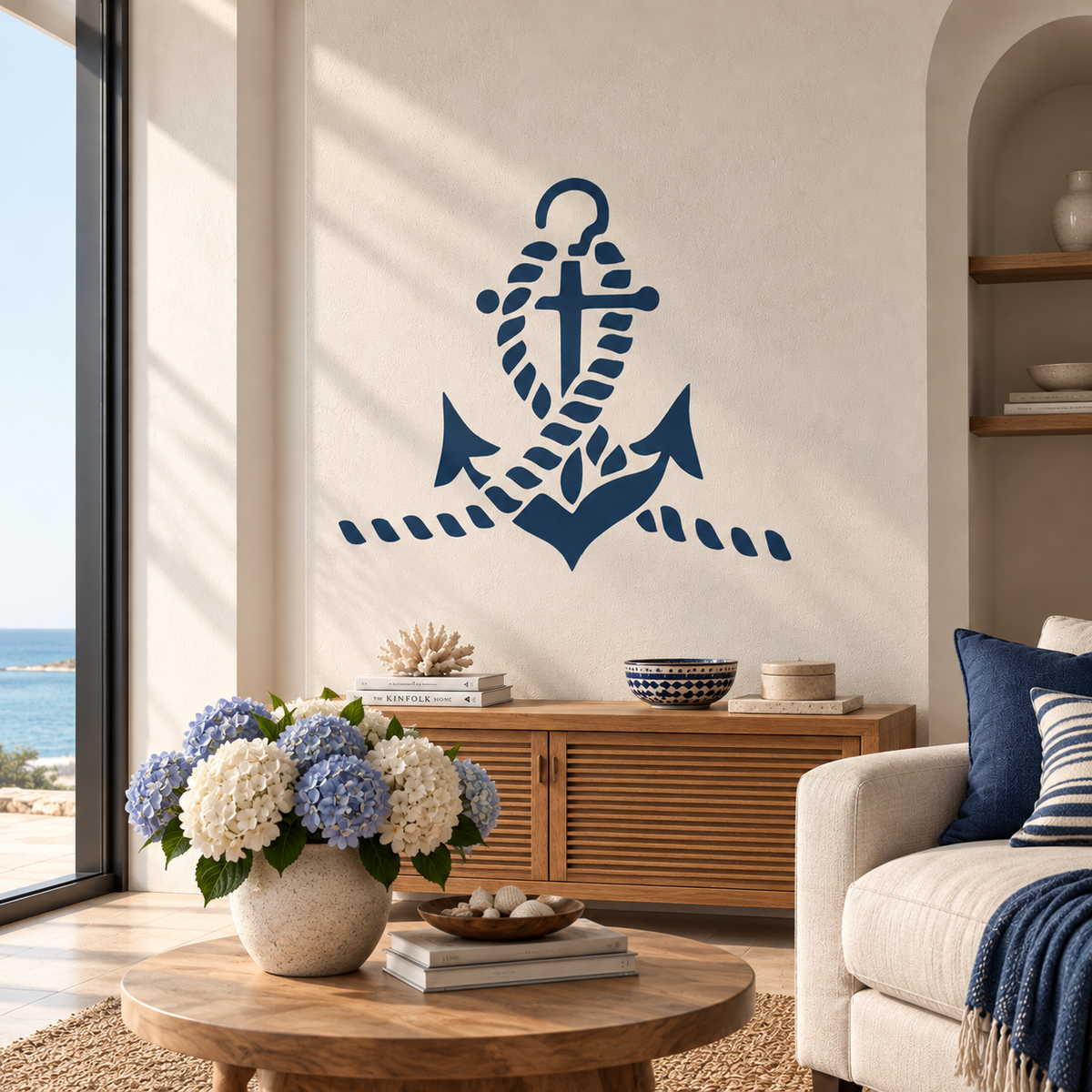 Navy blue Anchor Stencil with a nautical rope design on a white wall above a wooden cabinet in a bright coastal living room.