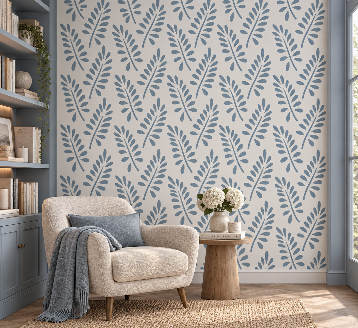 Blue botanical leaf wall stencil creating a soft repeating foliage pattern in a cozy modern reading corner.