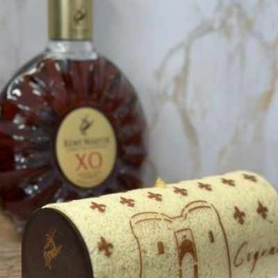 Cake decorated with custom Cognac stencil design next to Rémy Martin XO bottle