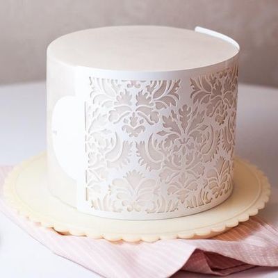 buttercream cake stencil with elegant floral pattern on smooth white cake