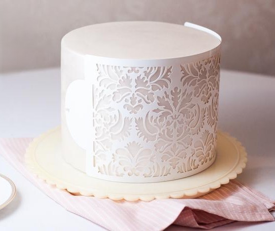 buttercream cake stencil with elegant floral pattern on smooth white cake