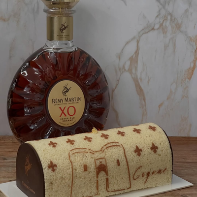 Cake stencil with fleur-de-lis pattern and Cognac design on a French dessert