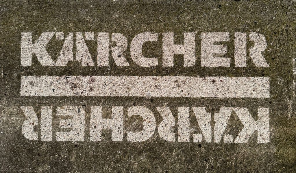 Custom pressure washer stencil used to create a clean branded design on concrete