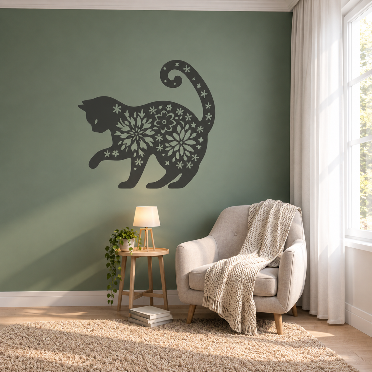 Large floral cat stencil on a muted green accent wall in a cozy reading nook with a cream armchair.
