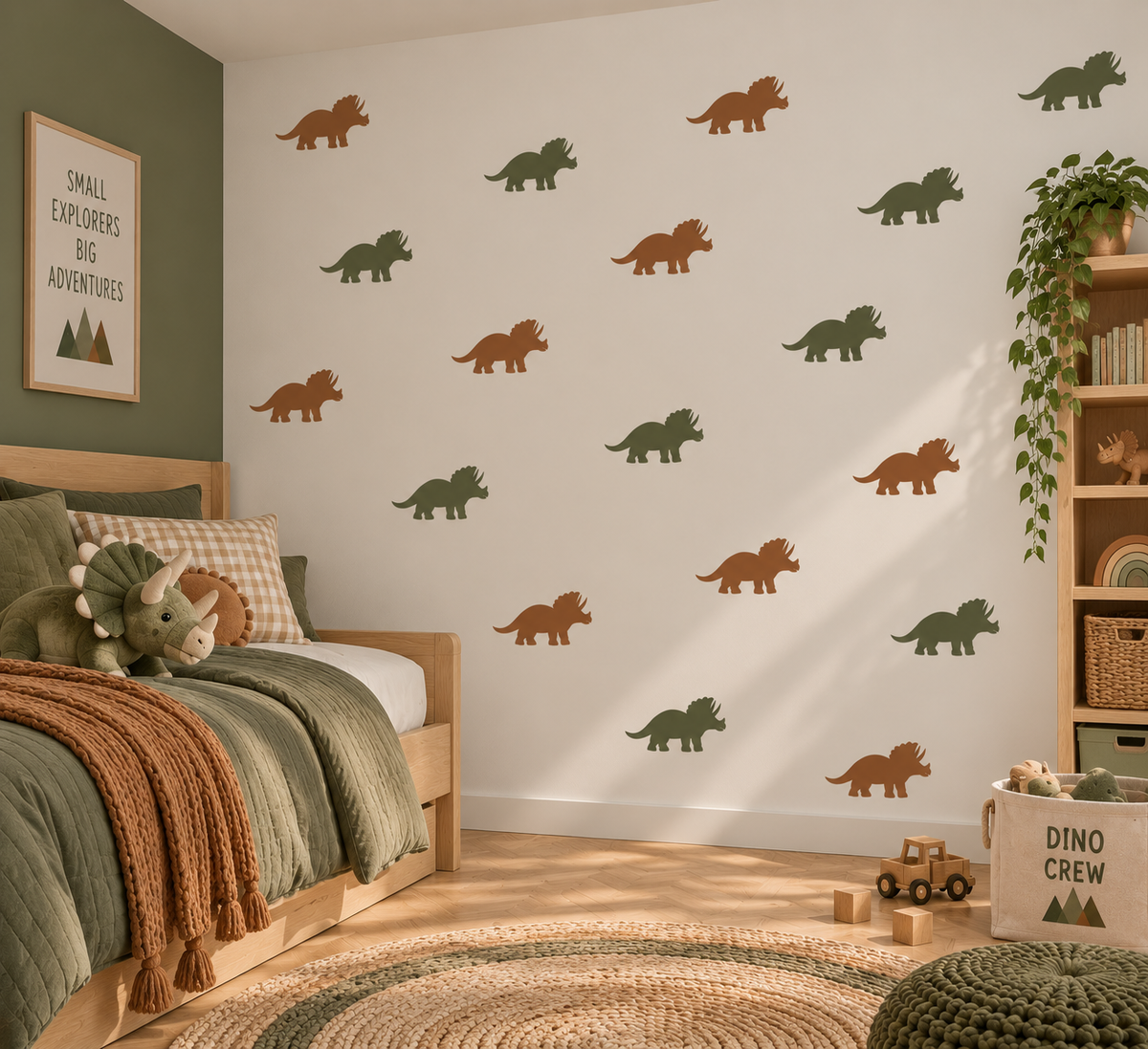 Green and rust Triceratops dinosaur stencils painted in a playful repeating pattern on a white wall in a cozy children’s bedroom with natural wooden furniture, dinosaur decor, soft green bedding, and warm neutral details.