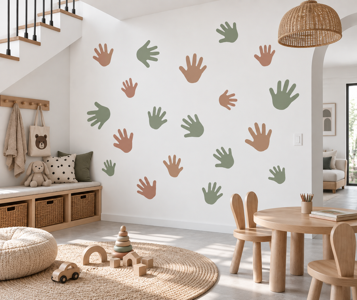 Handprint wall stencil in different sizes with soft sage and terracotta colors in a neutral kids playroom.