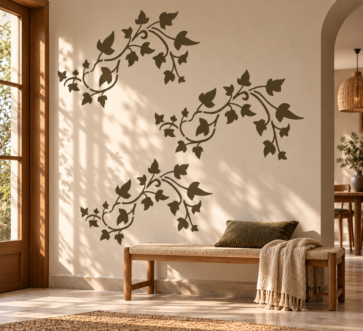 Ivy vine wall stencil in olive green featuring three flowing leafy branches above a wooden bench in a warm neutral entryway