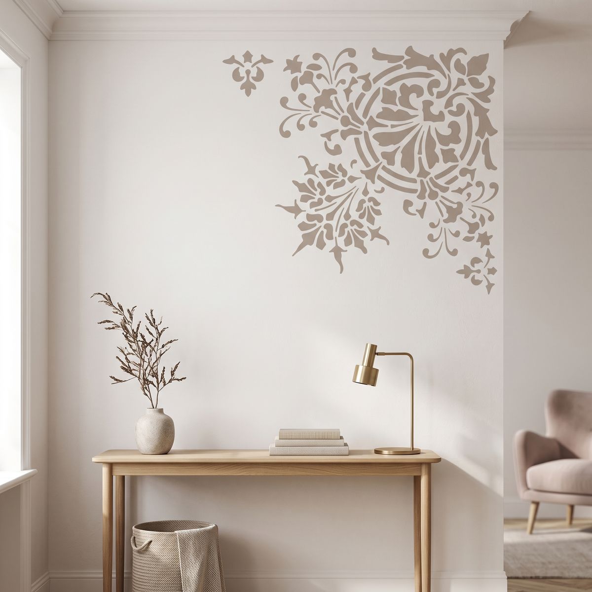 Ornamental floral corner stencil with an elegant decorative pattern painted on a neutral wall above a wooden console table.