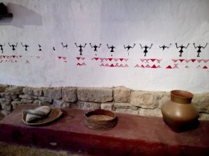 Wall stencil with prehistoric motifs used in a rustic interior with stone base