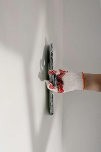 Skim coating the wall to prepare for stencil application during a dining room renovation