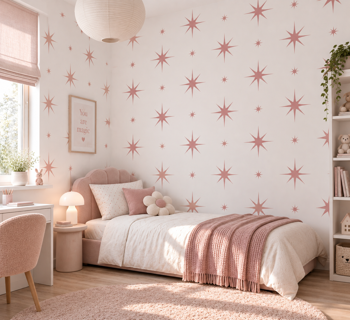 Dusty pink starburst wall stencils in assorted sizes painted across a white girls bedroom wall, creating a soft celestial feature wall.