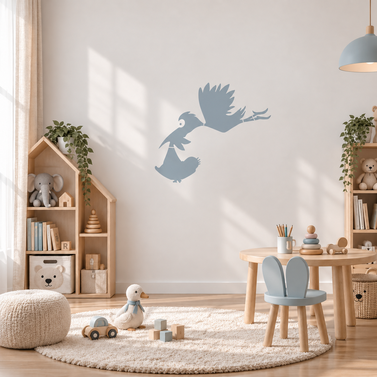Soft blue stork and baby wall stencil in a bright kids playroom.