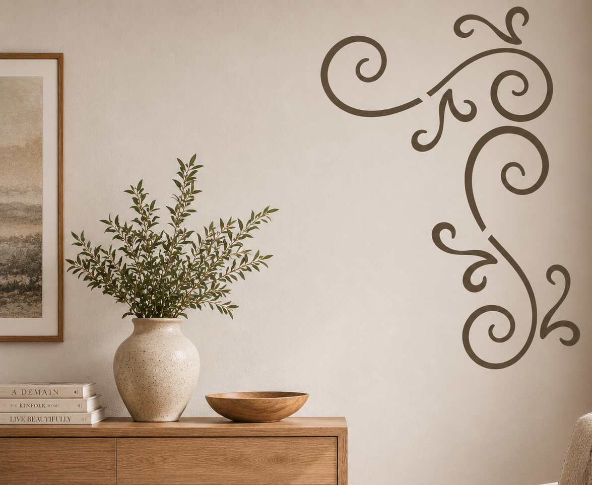 Swirl corner wall stencil with decorative scroll and flourish pattern painted on a neutral wall above a wooden cabinet.