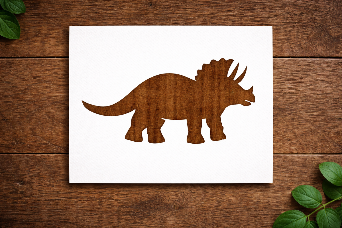 Reusable Triceratops dinosaur stencil made from 300 micron Mylar plastic placed on wooden background.