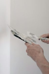 Skim coating the wall to prepare for stencil application during a dining room renovation