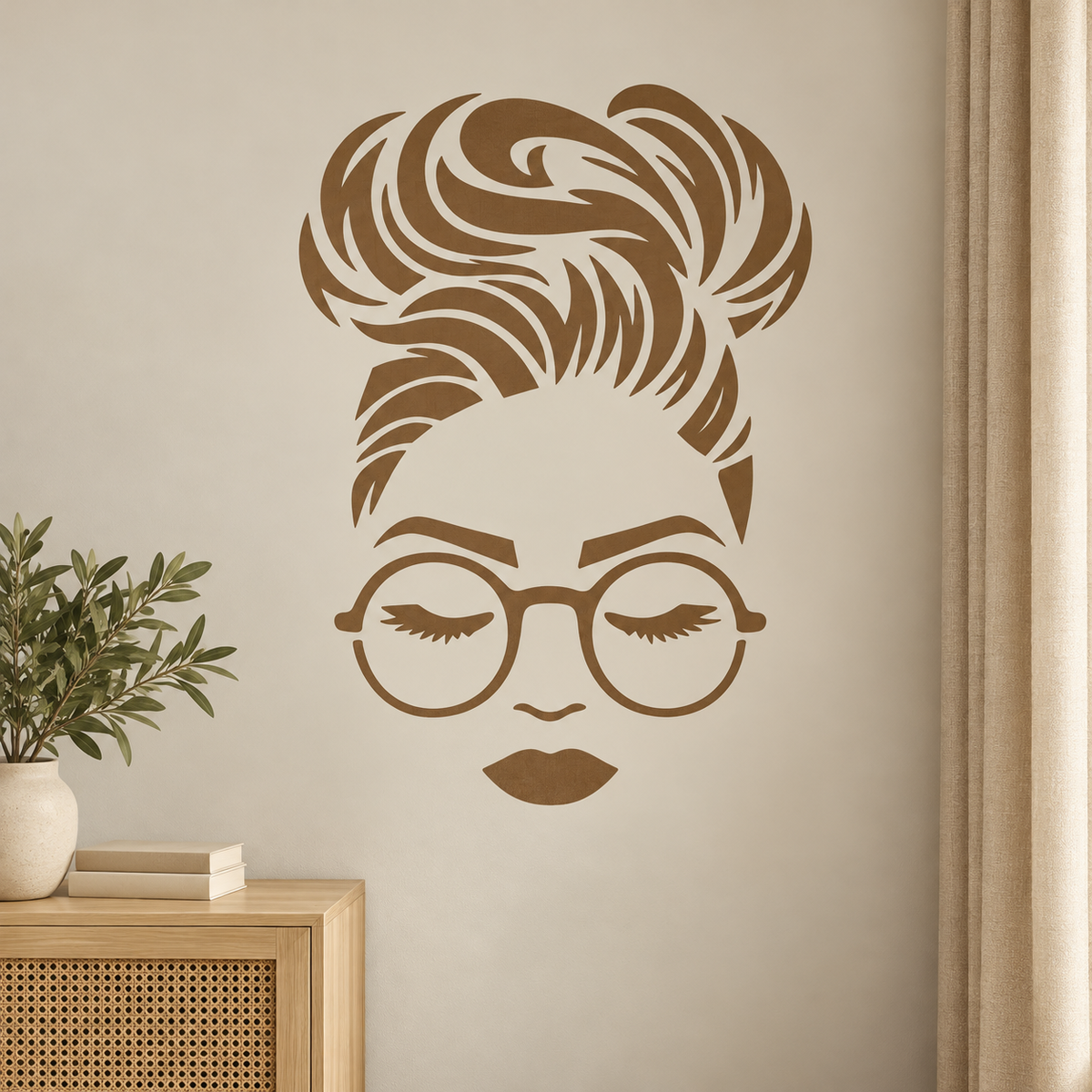 Warm brown Woman Face Stencil featuring a messy bun hairstyle, round glasses and closed eyes on a cream wall beside a wooden cabinet.